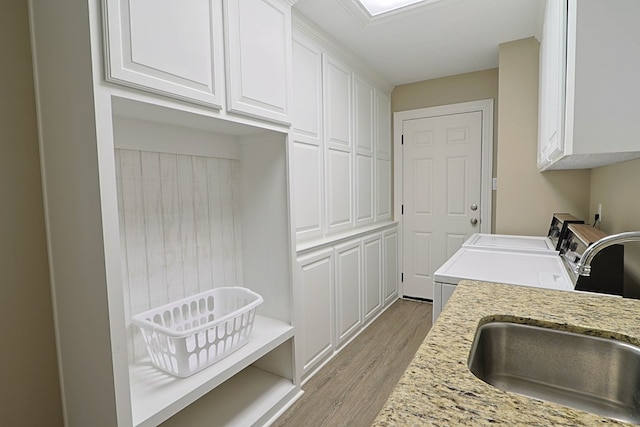 232 Cove Ln, Brookeland, TX 75931 - laundry area with washing machine and dryer, cabinet space, and light wood-style flooring