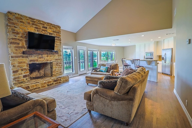 232 Cove Ln, Brookeland, TX 75931 - living area with light wood-type flooring, high vaulted ceiling, baseboards, and a fireplace