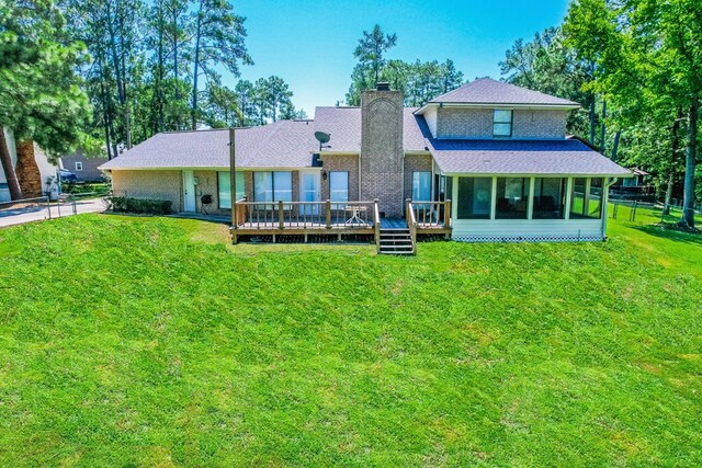 232 Cove Ln, Brookeland, TX 75931 - rear view of house with a chimney, a lawn, a wooden deck, and a sunroom