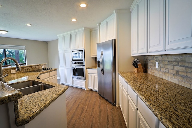 232 Cove Ln, Brookeland, TX 75931 - kitchen with appliances with stainless steel finishes, a sink, dark wood-style flooring, recessed lighting, and tasteful backsplash