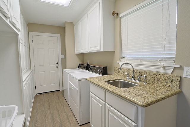 232 Cove Ln, Brookeland, TX 75931 - laundry area featuring washer and clothes dryer, light wood-style floors, and cabinet space