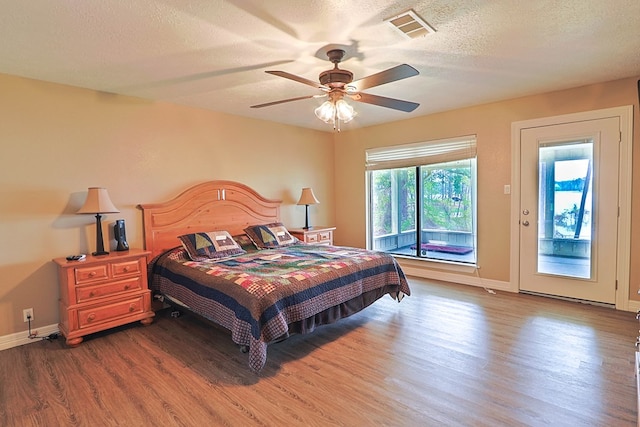 232 Cove Ln, Brookeland, TX 75931 - bedroom featuring wood finished floors, a textured ceiling, baseboards, and ceiling fan