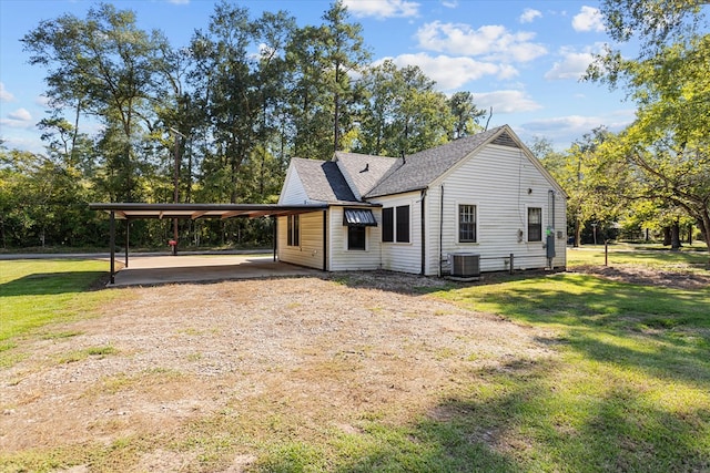 view of front of property with central AC, a front lawn, and a carport