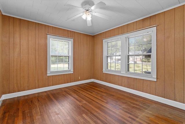 unfurnished room with hardwood / wood-style flooring, ornamental molding, and wooden walls