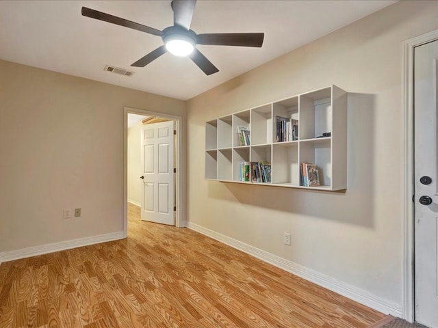 empty room with ceiling fan and light hardwood / wood-style floors