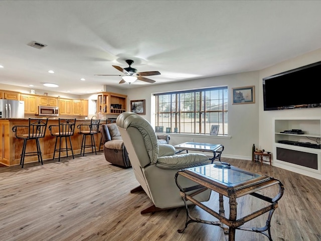 living room featuring light hardwood / wood-style floors and ceiling fan