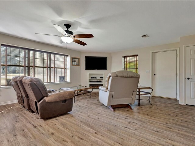 living room featuring ceiling fan and light hardwood / wood-style flooring