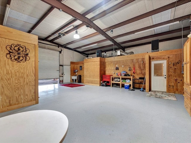 garage featuring a workshop area and wood walls