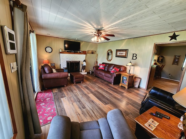 493 Hideaway Loop, Hemphill, TX 75948 - living area featuring a ceiling fan, a brick fireplace, wood finished floors, and wooden walls