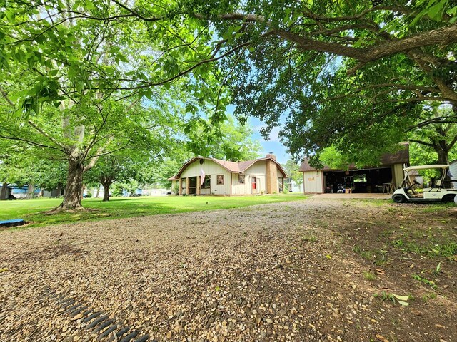 493 Hideaway Loop, Hemphill, TX 75948 - view of green lawn featuring an outbuilding and driveway
