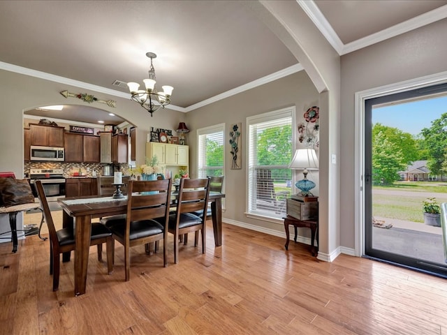 166 White Oak Ln, Lufkin, TX 75904 - dining area with a chandelier, arched walkways, light wood-style floors, and ornamental molding