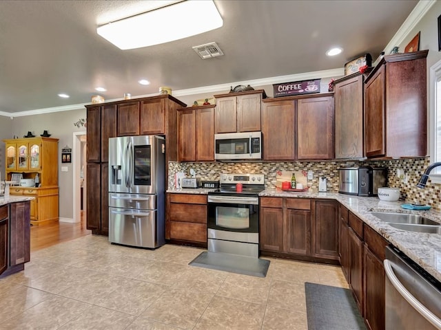 166 White Oak Ln, Lufkin, TX 75904 - kitchen featuring appliances with stainless steel finishes, crown molding, light tile patterned floors, tasteful backsplash, and light stone counters