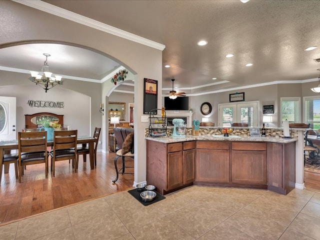 166 White Oak Ln, Lufkin, TX 75904 - kitchen featuring light tile patterned floors, ceiling fan, brown cabinetry, a chandelier, and recessed lighting