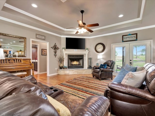 166 White Oak Ln, Lufkin, TX 75904 - living area with a tray ceiling, wood finished floors, ornamental molding, french doors, and a warm lit fireplace