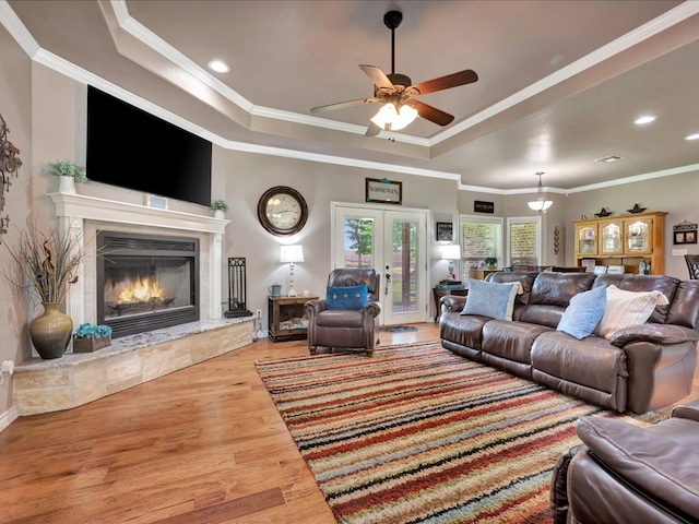 166 White Oak Ln, Lufkin, TX 75904 - living room featuring a tray ceiling, wood finished floors, a ceiling fan, a glass covered fireplace, and ornamental molding
