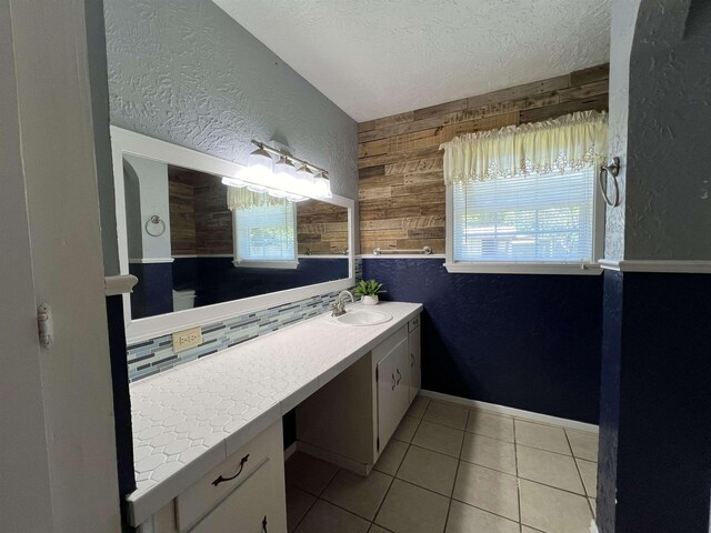 bathroom featuring tile patterned floors, wooden walls, plenty of natural light, and vanity