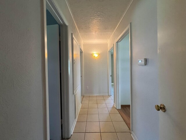 hallway featuring light tile patterned floors and a textured ceiling