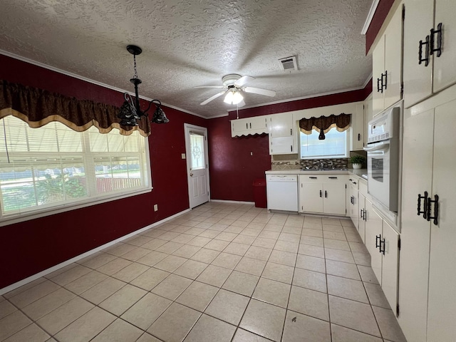 kitchen featuring white appliances, white cabinets, ceiling fan with notable chandelier, hanging light fixtures, and light tile patterned flooring