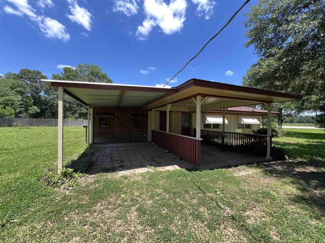 exterior space with a carport and a yard