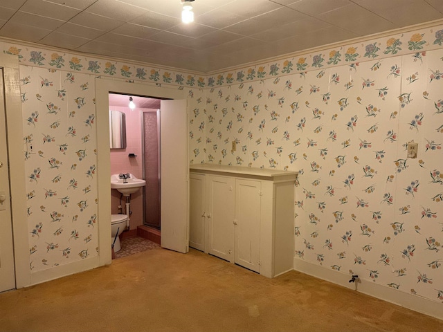 interior space featuring light carpet, ensuite bathroom, and ornamental molding