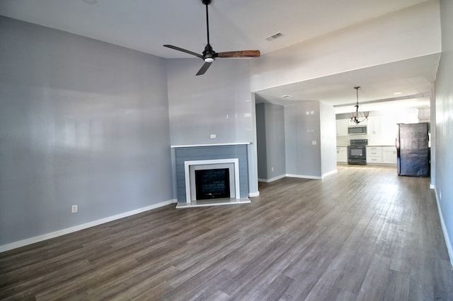 322 Montrose, Lufkin, TX 75901 - unfurnished living room with dark wood-type flooring, a ceiling fan, baseboards, a fireplace, and a high ceiling
