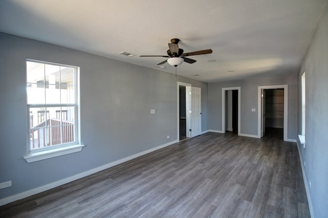 unfurnished room with ceiling fan, dark hardwood / wood-style floors, and a textured ceiling