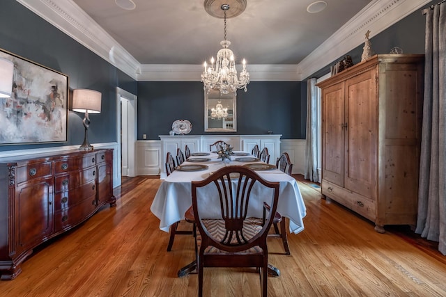 dining area featuring ornamental molding, a chandelier, and light wood-type flooring