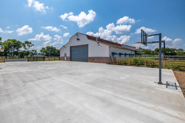 view of home's exterior featuring basketball hoop and a garage