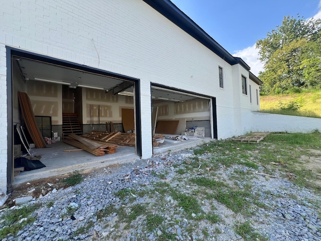 view of side of property featuring a garage and brick siding