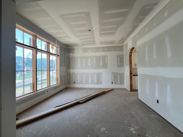 empty room featuring a healthy amount of sunlight and a mountain view