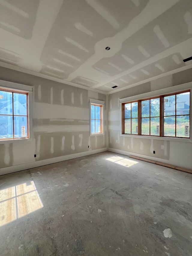 spare room featuring plenty of natural light and concrete flooring