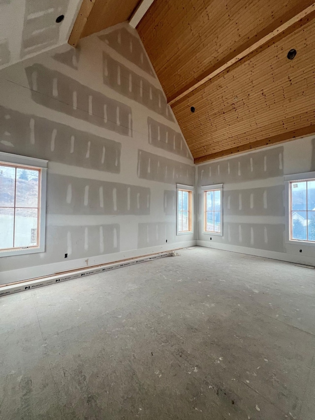 empty room with high vaulted ceiling, plenty of natural light, and wood ceiling