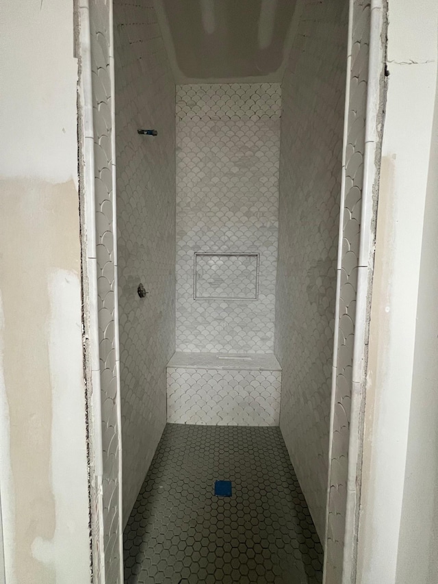 full bath with a tile shower and tile patterned floors