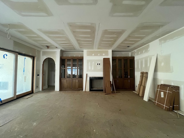 unfurnished living room featuring arched walkways