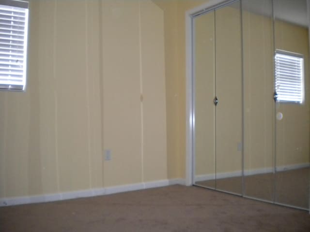 unfurnished bedroom with dark colored carpet