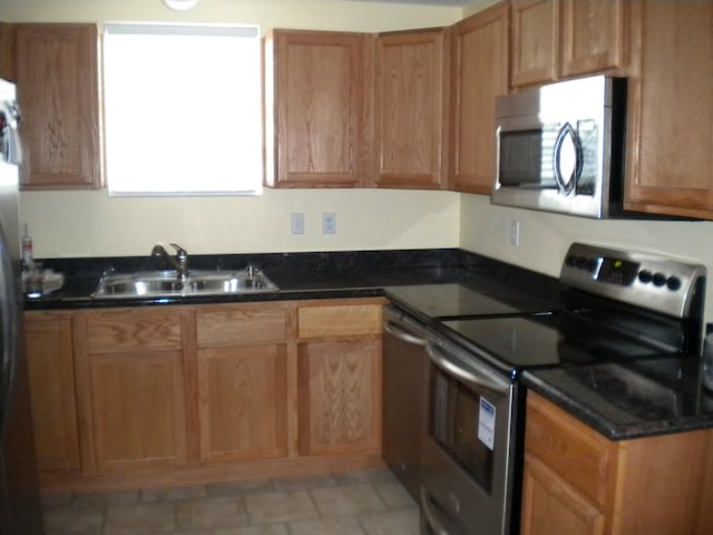 kitchen featuring light tile flooring, appliances with stainless steel finishes, and sink