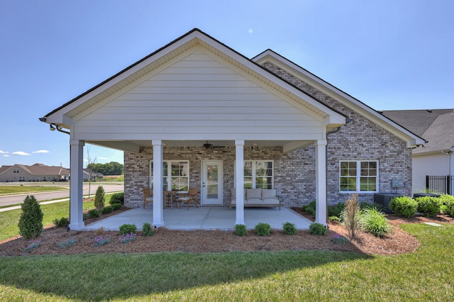 view of front of property featuring a patio area, ceiling fan, central AC unit, and a front lawn