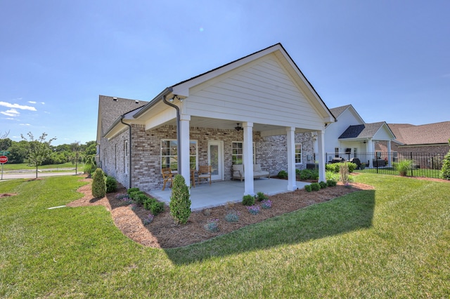 exterior space featuring a patio area, ceiling fan, and a lawn