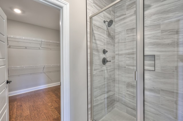 bathroom featuring wood-type flooring and a shower with door