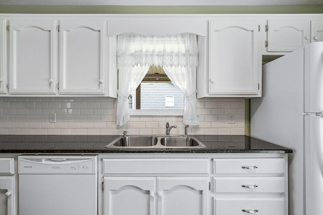 kitchen featuring white appliances, white cabinets, backsplash, dark stone countertops, and sink