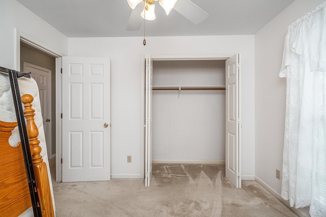 unfurnished bedroom with light colored carpet, a closet, and ceiling fan