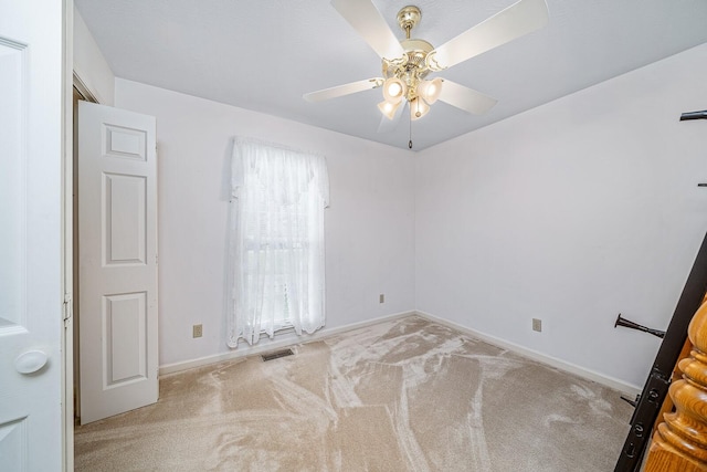 spare room featuring ceiling fan and light colored carpet