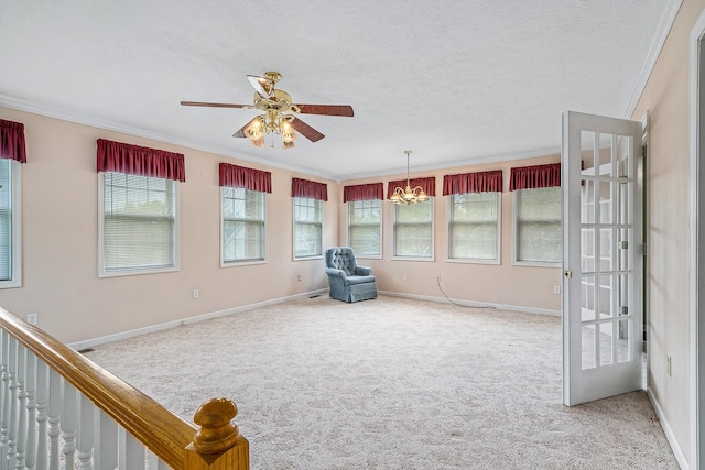 unfurnished room featuring a textured ceiling, crown molding, ceiling fan with notable chandelier, and light colored carpet