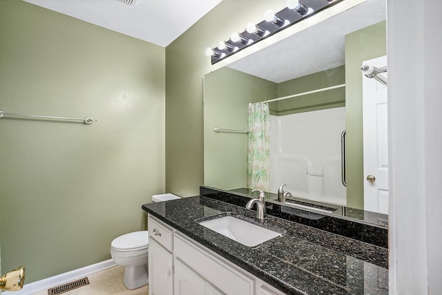 bathroom with tile floors, toilet, and vanity with extensive cabinet space