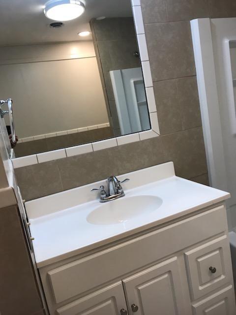 bathroom featuring vanity and tile walls