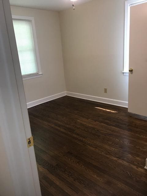 spare room featuring dark wood-type flooring