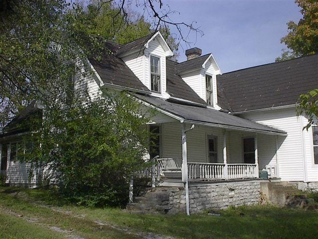 view of side of property featuring covered porch