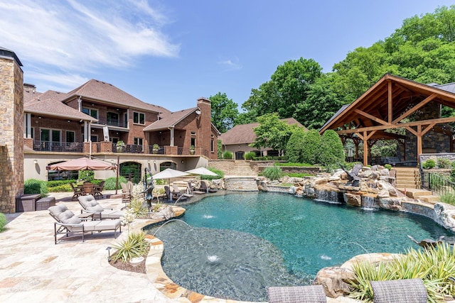 view of swimming pool with a gazebo, pool water feature, and a patio area