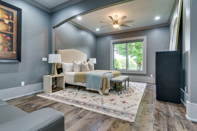 bedroom featuring ceiling fan, ornamental molding, and dark wood-type flooring