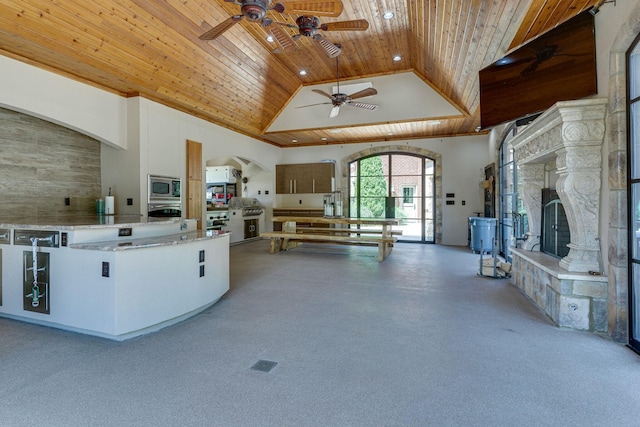 kitchen featuring high vaulted ceiling, stainless steel appliances, wooden ceiling, and ceiling fan